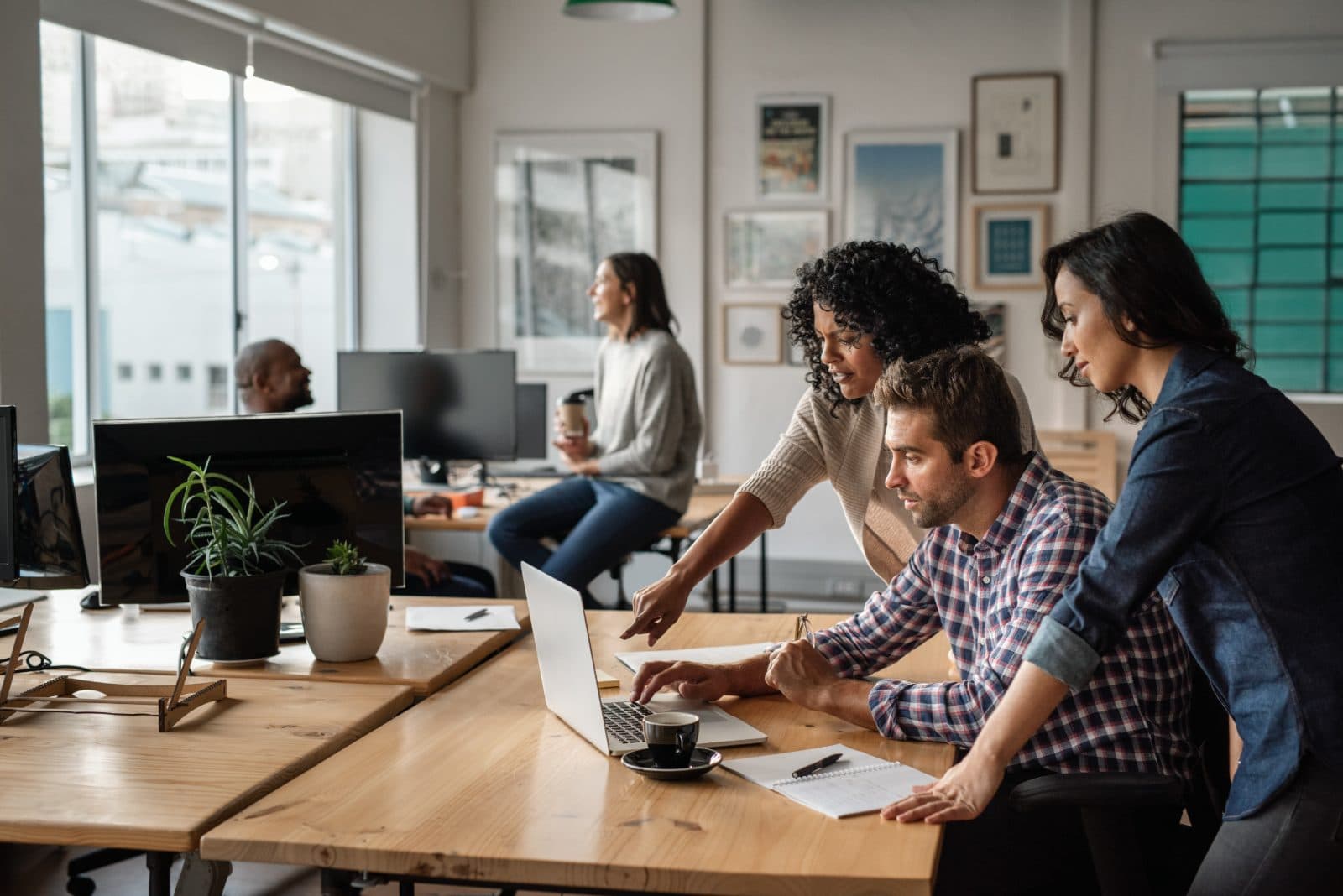 A small team collaborating on a website around a laptop